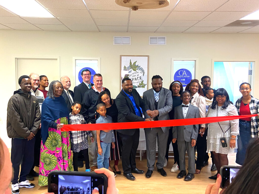 Tony Ngoupou and Chris Emtcheu of C& A Financial Services and Business Consulting cut the red ribbon in front of their offices surrounded by family and friends.