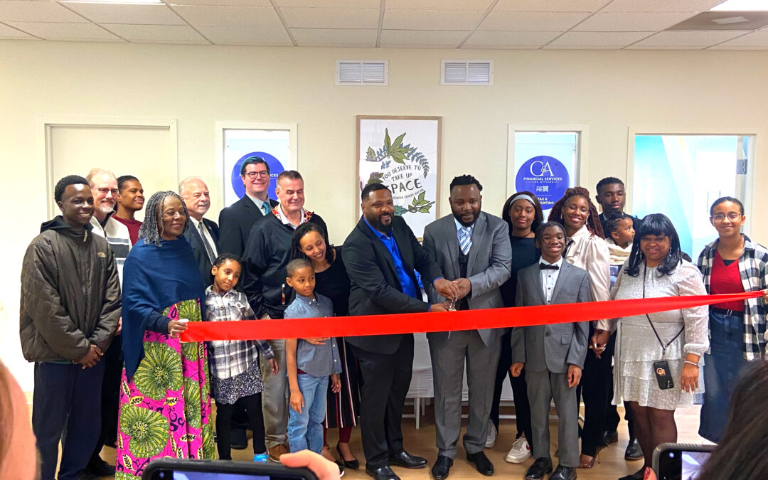 Tony Ngoupou and Chris Emtcheu of C& A Financial Services and Business Consulting cut the red ribbon in front of their offices surrounded by family and friends.